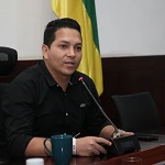 Nestor Ivan Rodriguez sentado. La bandera de colombia junto a el.