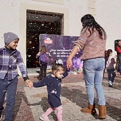 Grupo de niño, niña y madre bailando en la plaza