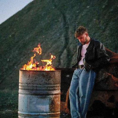 dani fernandez frene a un fuego en un tonel de lata