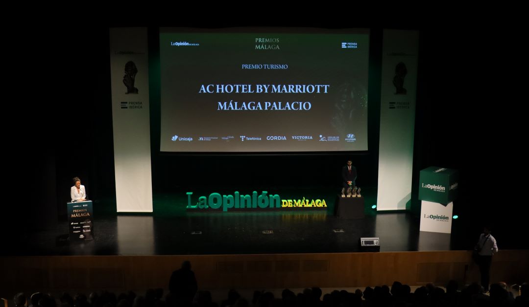 Premiados en el escenario del AC HOTEL BY MARRIOTT MÁLAGA PALACIO y escenario con presentadora.