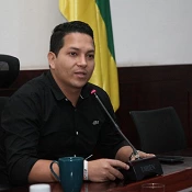 Nestor Ivan Rodriguez sentado. La bandera de colombia junto a el.