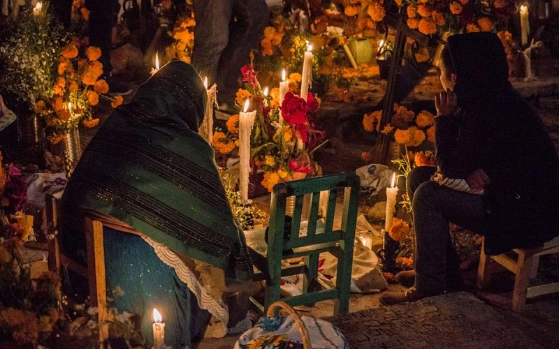 Una vibrante celebracion del Dia de Muertos iluminada por velas y con ofrendas en Janitzio Mexico